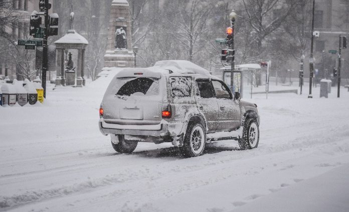 Затрупана улица със сняг, кола.
