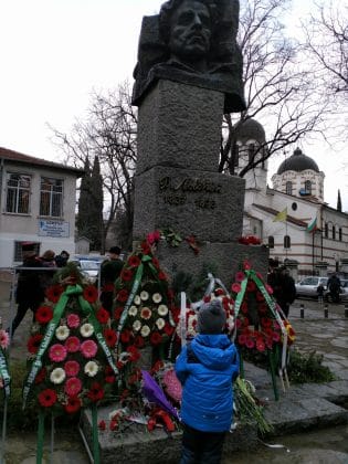 Дете поднася цветя пред паметника на Васил Левски