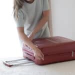 Млада жена опакова куфар в хотелска стая