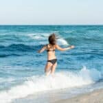 Момиче на плаж се къпе в морето през лятото 2