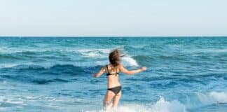 Момиче на плаж се къпе в морето през лятото 2