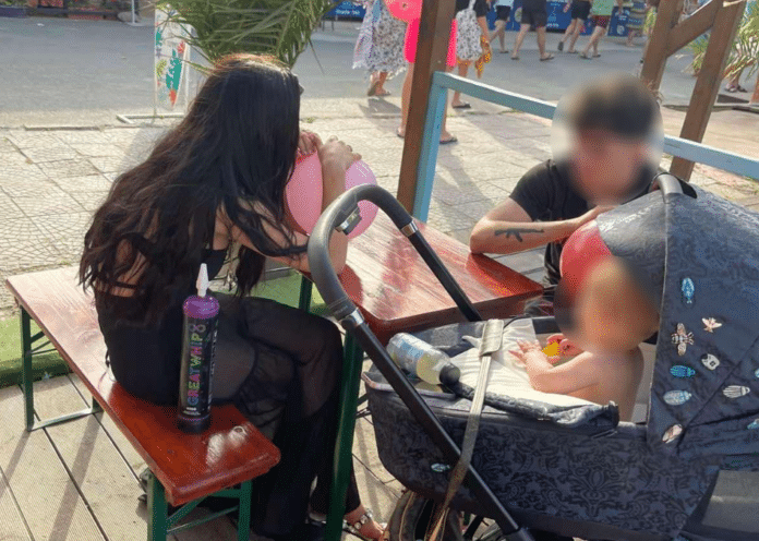 Родители дишат райски газ от балон пред своето бебе